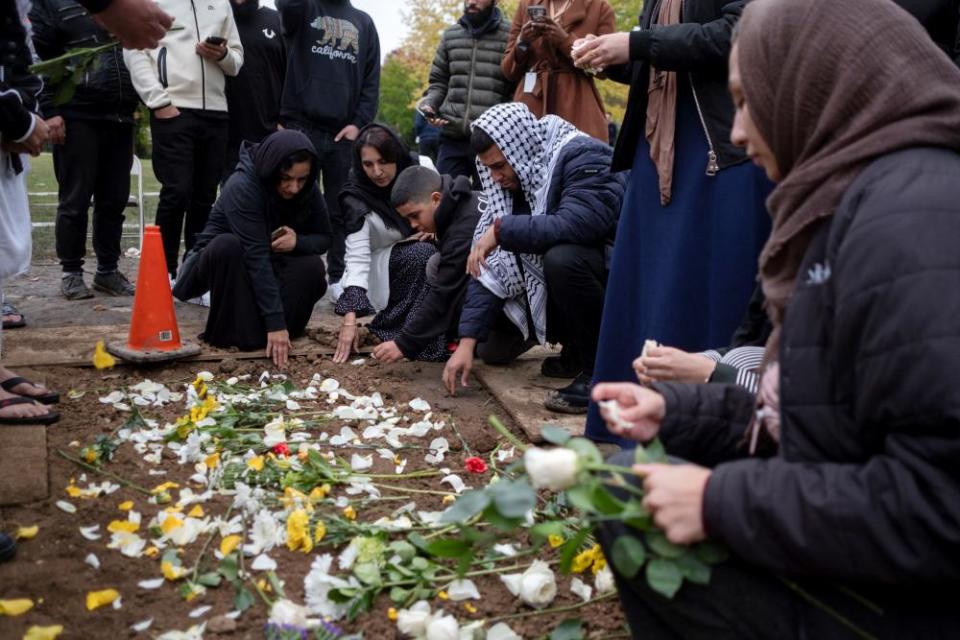Mourners place flowers at the grave of Wadea Al-Fayoume at Parkholm Cemetery where the burial took place in LaGrange, Illinois, on 16 October.
