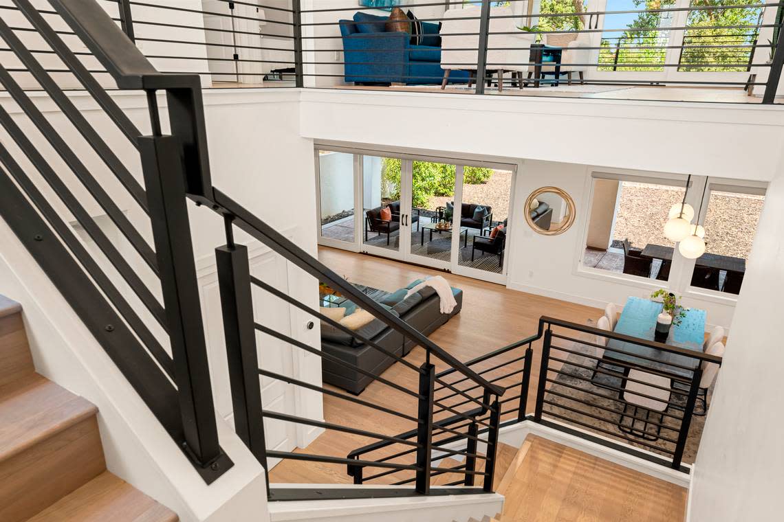 A sleek stairway leads to a loft upstairs.