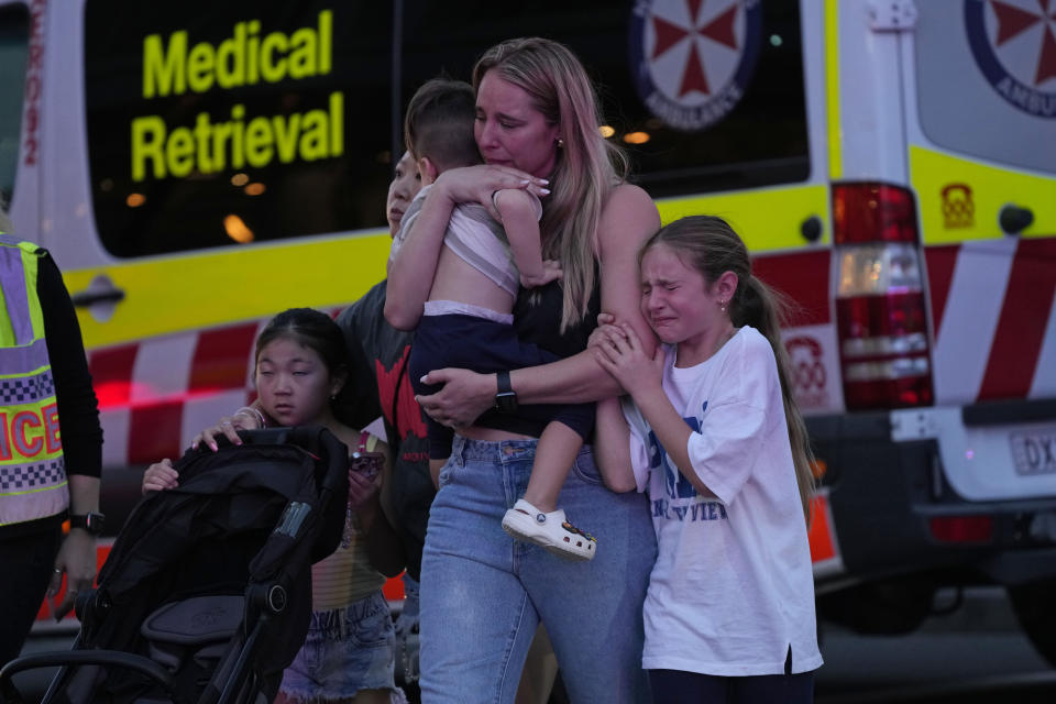 People are led out from the Westfield Shopping Centre where multiple people were stabbed in Sydney, Saturday, April 13, 2024. A man stabbed six people to death at the busy Sydney shopping center Saturday before he was fatally shot, police said. (AP Photo/Rick Rycroft)