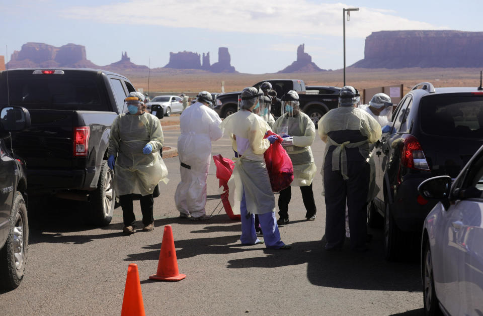 FILE - A team made up of nurses, an emergency medical technician, dental workers, an X-ray technician, a lab technician, administrative workers, maintenance workers and an emergency manager test people for COVID-19 outside of the Monument Valley Health Center in Oljato-Monument Valley, San Juan County, on Friday, April 17, 2020. In a pandemic that has seen sharp divides between urban and rural vaccination rates nationwide, Arizona is the only state where rural vaccine rates outpaced more populated counties, according to a recent report from the U.S. Centers for Disease Control and Prevention. (Kristin Murphy/The Deseret News via AP, File)