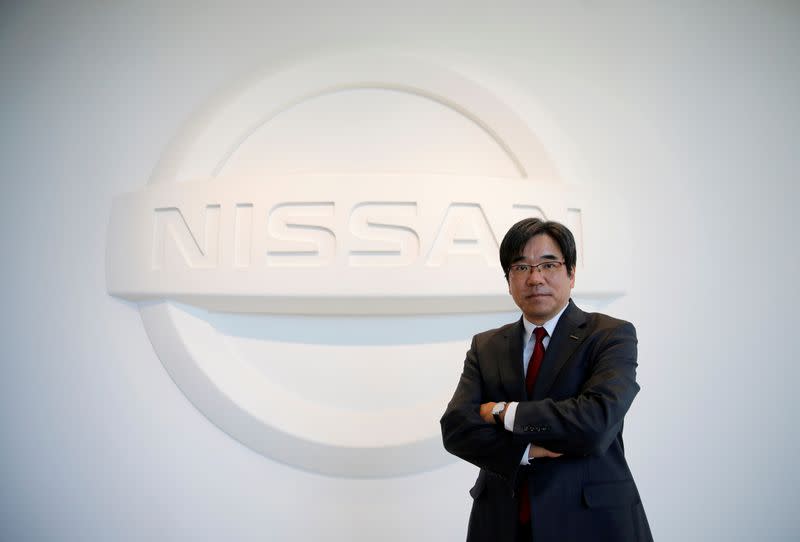 FILE PHOTO: Nissan Executive Vice President Sakamoto poses with the carmaker's logo in the showroom at the carmaker's headquarters in Yokohama