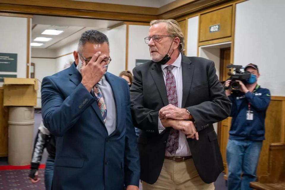 Former Pasco police officer Richard Aguirre hides his face as he leaves Spokane County Superior Court with lawyer John Browne in this Spokesman-Review photo. The jury in Aguirre’s first-degree murder case was unable to come to a verdict, triggering a mistrial.