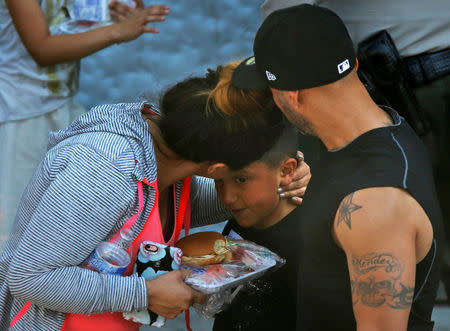 REFILE -- CORRECTING TYPO -- A student who was evacuated after a shooting at North Park Elementary School is embraced after groups of them were reunited with parents waiting at a high school in San Bernardino, California, U.S. April 10, 2017. REUTERS/Mario Anzuoni