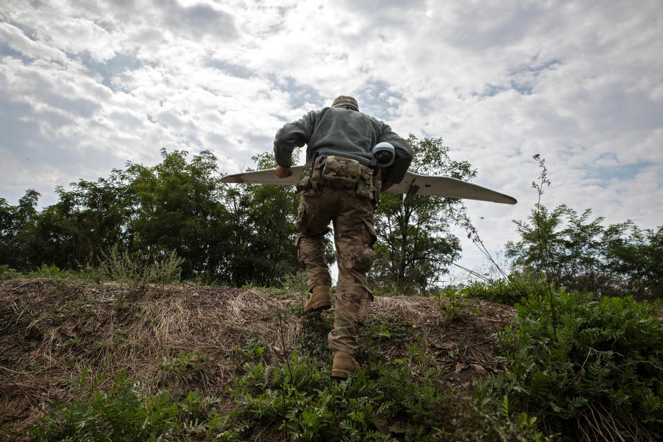 Oleksandr Ivantsov sube una pequeña colina mientras lleva un dron en la región de Donetsk, Ucrania, el sábado 27 de agosto de 2023. (Tyler Hicks/The New York Times)
