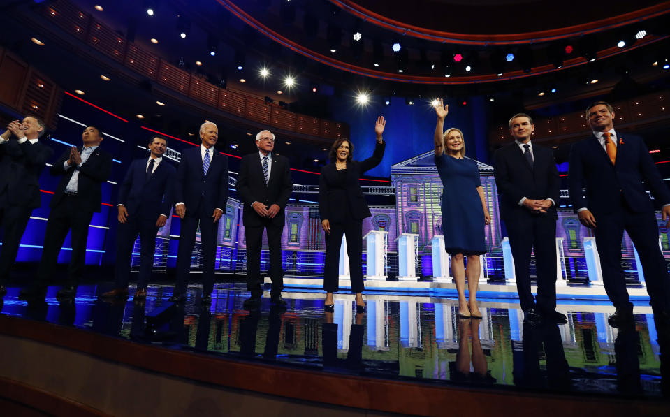 Democratic presidential candidates from left, former Colorado Gov. John Hickenlooper, entrepreneur Andrew Yang, South Bend Mayor Pete Buttigieg, former Vice-President Joe Biden, Sen. Bernie Sanders, I-Vt., Sen. Kamala Harris, D-Calif., Sen. Kristen Gillibrand, D-N.Y., former Colorado Sen. Michael Bennet and Rep. Eric Swalwell, D-Calif., wave as they enter the stage for the second night of the Democratic primary debate hosted by NBC News at the Adrienne Arsht Center for the Performing Arts, Thursday, June 27, 2019, in Miami. (AP Photo/Brynn Anderson)