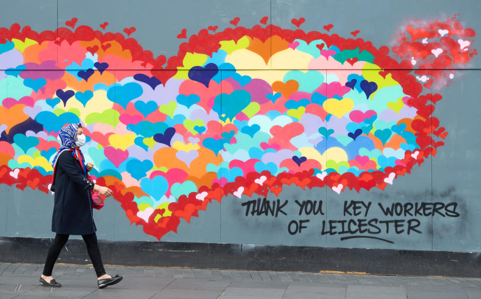 A woman wearing a protective face mask walks past artwork in Leicester city centre, as the city�s spike in coronavirus cases has sparked a report that it may be the first UK location to be subjected to a district lockdown.