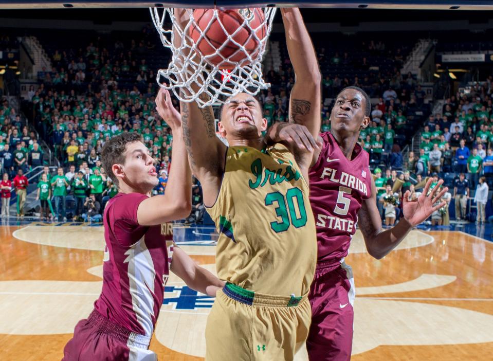 Dec 13, 2014; South Bend, IN, USA; Notre Dame Fighting Irish forward Zach Auguste (30) dunks as Florida State Seminoles center Boris Bojanovsky (15) and forward Jarquez Smith (5) defend in the second half at the Purcell Pavilion. Notre Dame won 83-63. Mandatory Credit: Matt Cashore-USA TODAY Sports