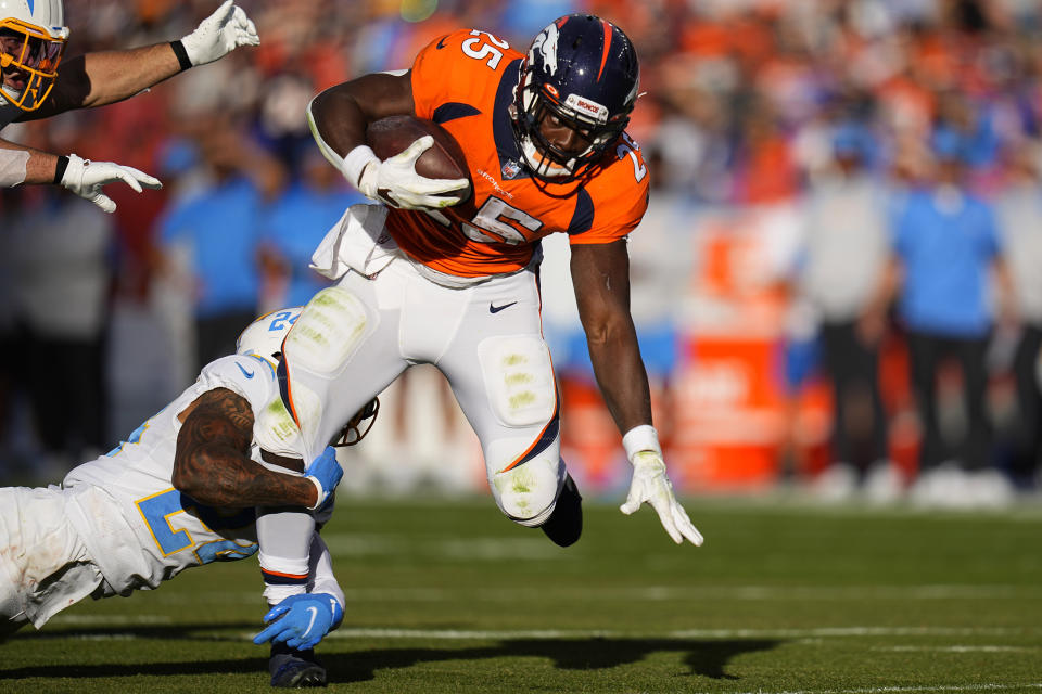 Denver Broncos running back Melvin Gordon (25) is tackled by Los Angeles Chargers safety Nasir Adderley (24) during the first half of an NFL football game, Sunday, Nov. 28, 2021, in Denver. (AP Photo/Jack Dempsey)