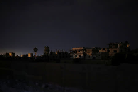 Destroyed buildings are seen from of a train traveling back from recently opened international fair in Damascus, Syria, September 12, 2018. REUTERS/Marko Djurica/Files