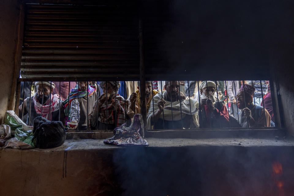 Nomadic Kashmiri men look through the window of community kitchen as they wait for the special prayers to start outside the forest shrine of Sufi saint Mian Nizamuddin Kiyanwi in Baba Nagri, northeast of Srinagar, Indian controlled Kashmir, Saturday, June 8, 2024. (AP Photo/Dar Yasin)