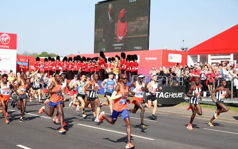 Sir Mo Farah makes his way past the video screen of Queen Elizabeth II  - Credit: Adam Davy/PA Wire