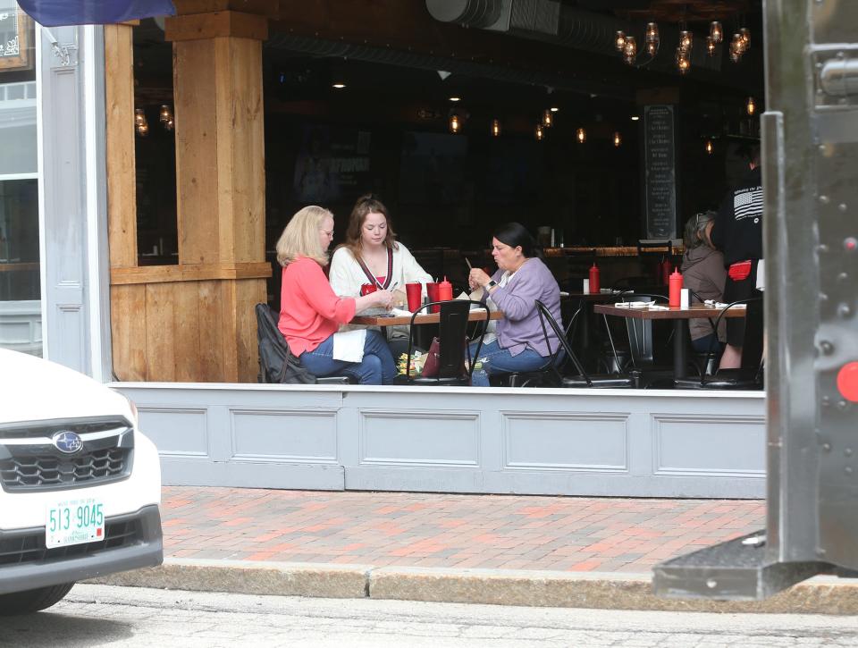 Diners are seen having lunch in an open-air environment at The Goat as warm weather arrives in Portsmouth prior to Memorial Day 2024.