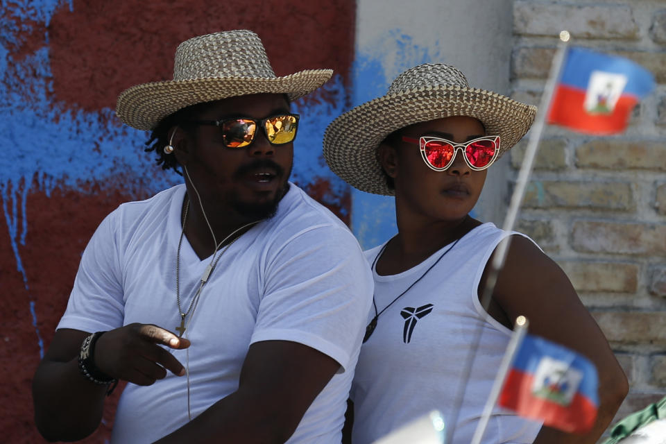 People look on from a motorcycle on the edge of a march led by the art community demanding the resignation of Haitian President Jovenel Moïse, in Port-au-Prince, Haiti, Sunday, Oct. 13, 2019.Thousands of Haitians joined a largely peaceful protest called by the art community Sunday to demand that Moïse step down, increasing pressure on the embattled leader after nearly a month of marches that have shuttered schools and businesses.(AP Photo/Rebecca Blackwell)