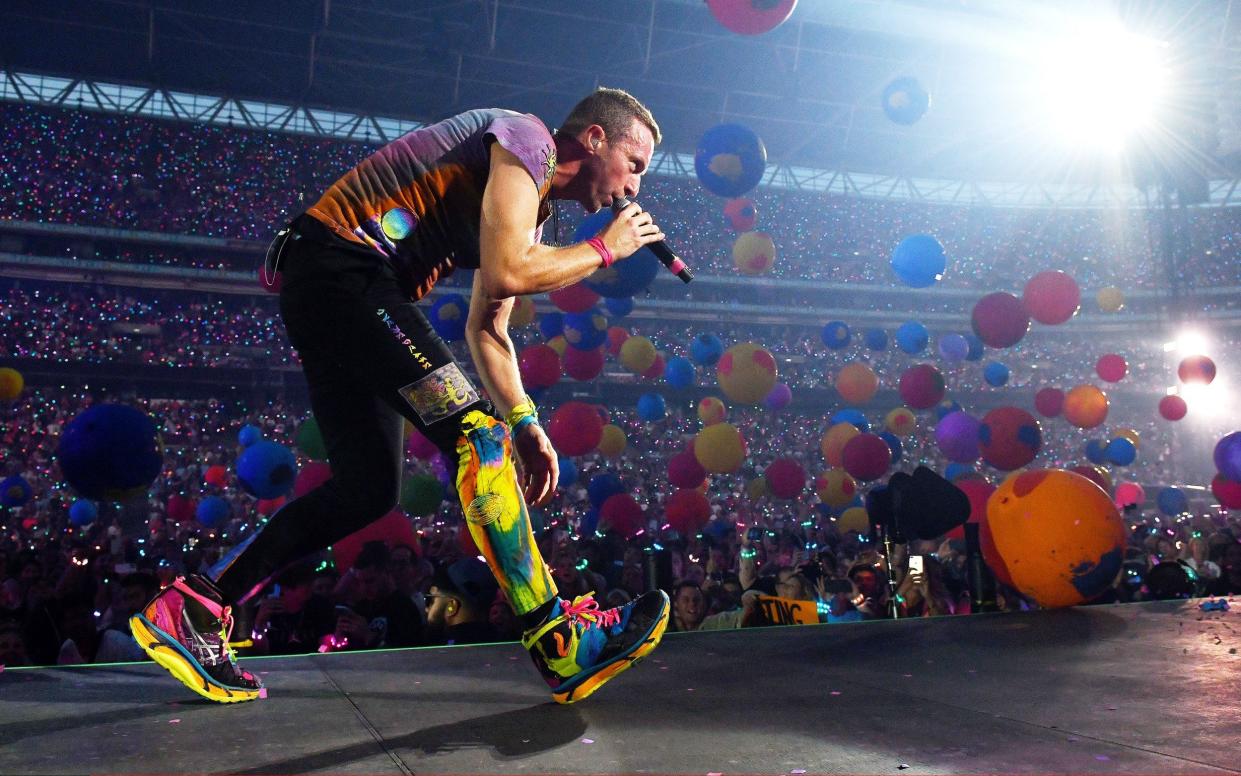 Chris Martin of Coldplay performing on stage at Wembley Stadium