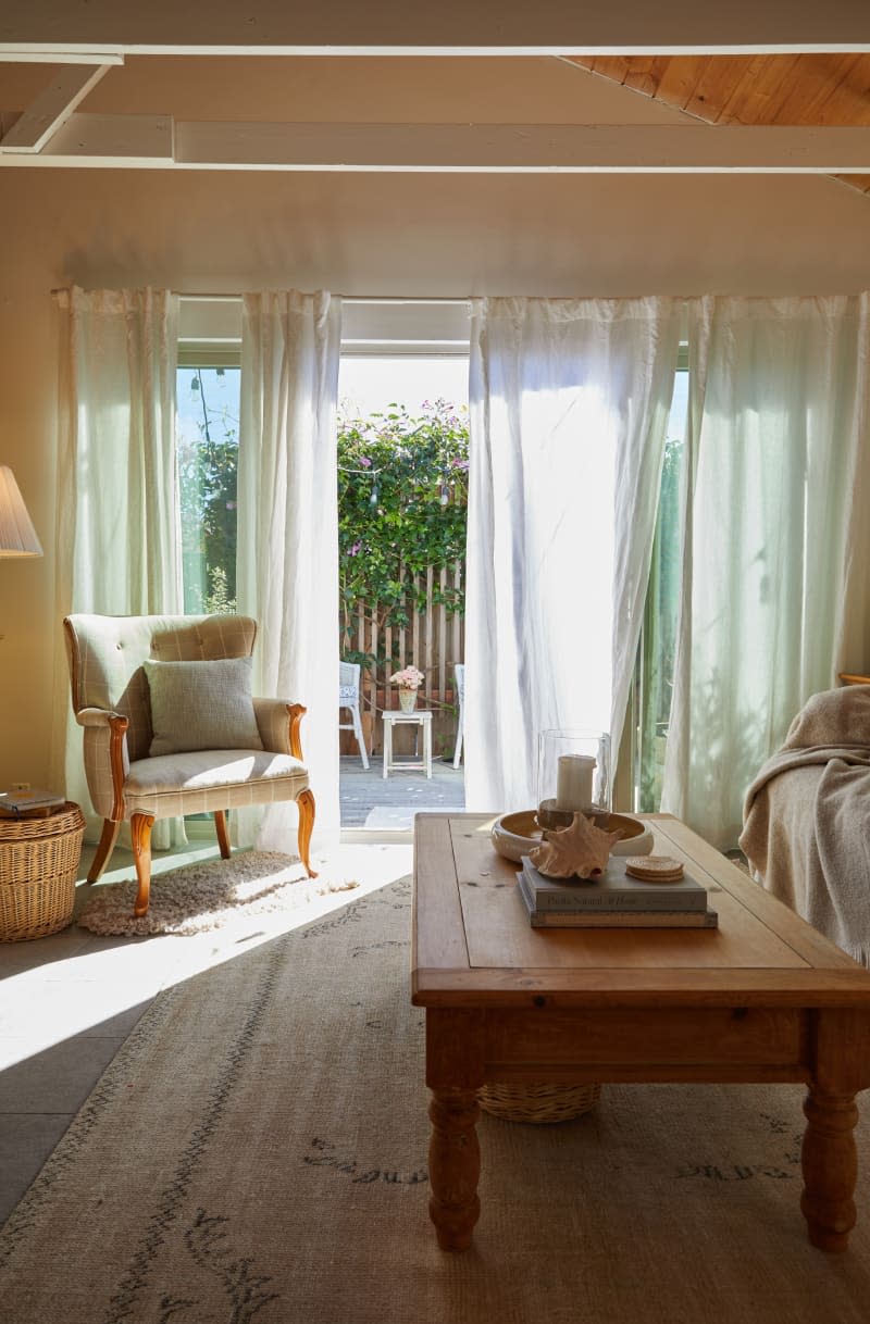 A reading chair sits on a rug next to a wicker basket.