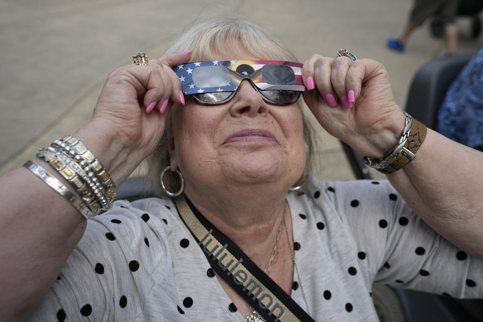 Karen Horn of Lantana, Texas, uses sun glasses to watch the beginning of the solar eclipse from Fort Worth, Texas, on Monday, April 8, 2024. (AP Photo/LM Otero)