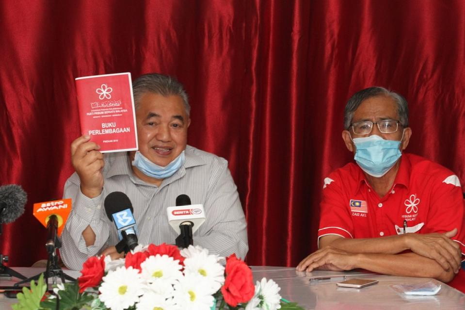 Johor Bersatu deputy chief Md Nasir Hashim (left) shows the party’s constitution book as Bersatu Johor Baru division chief Zais Mohd Akil looks on during the press conference in Johor Bari May 29, 2020. — Picture by Ben Tan