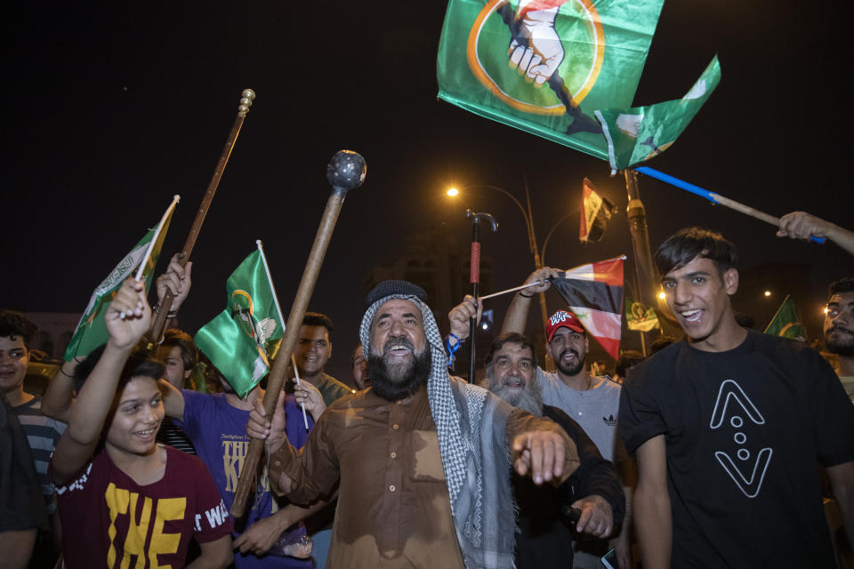 Followers of Shiite cleric Muqtada al-Sadr celebrate after the announcement of the results of the parliamentary elections in Tahrir Square, Baghdad, Iraq, Monday, Oct. 11, 2021. Iraq's Independent High Electoral Commission (IHEC) announced the parliamentary results of the November 10 vote which suggested that al-Sadr is the current front-runner with initial results coming from several Iraqi provinces. (AP Photo/Hadi Mizban)