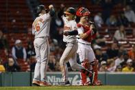 Baltimore Orioles' Gunnar Henderson, center, celebrates after his two-run home run in front of Boston Red Sox's Reese McGuire, right, that also drove in Ryan Mountcastle (6) during the sixth inning of a baseball game, Monday, Sept. 26, 2022, in Boston. (AP Photo/Michael Dwyer)