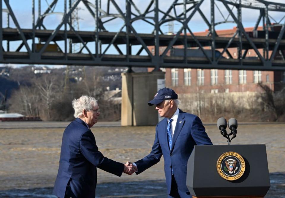 Biden, right, shakes hands with Senate Minority Leader Mitch McConnell during an event highlighting the bipartisan infrastructure law in front of the Clay Wade Bailey Bridge in Covington, Kentucky, on January 4, 2023<span class="copyright">Jim Watson—AFP via Getty Images</span>