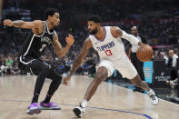 Los Angeles Clippers forward Paul George (13) dribbles next to Brooklyn Nets center Nic Claxton during the first half of an NBA basketball game, Sunday, Jan. 21, 2024, in Los Angeles. (AP Photo/Marcio Jose Sanchez)