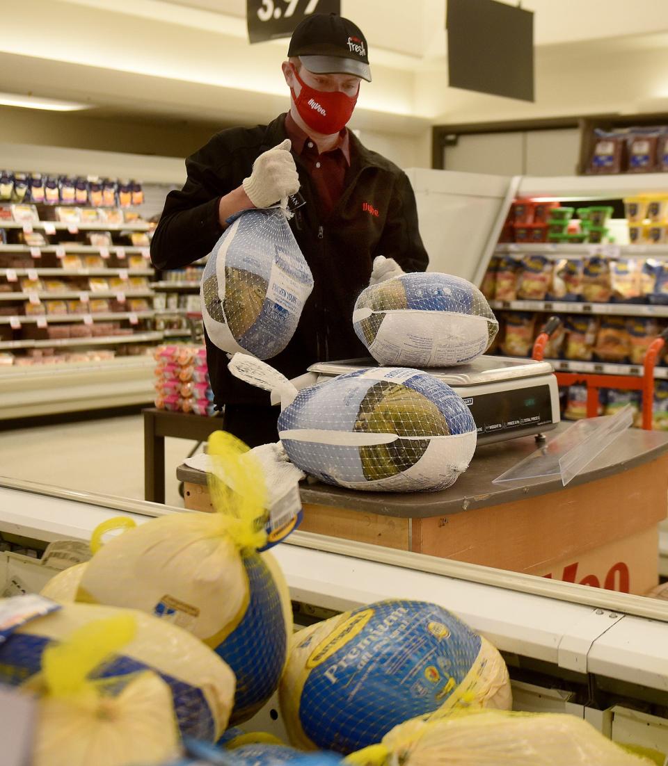 Hy-Vee Grocery Store meat market manager Brendan James weighs turkeys before pricing them on Friday at the Hy-Vee grocery store at 3100 W. Broadway.