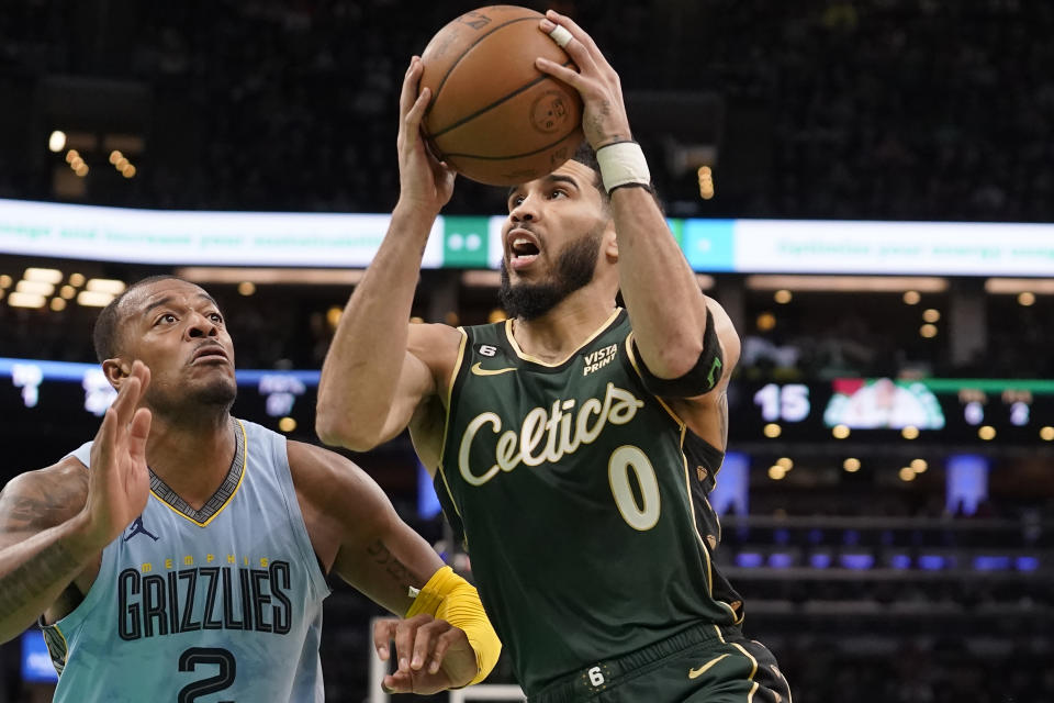 Boston Celtics forward Jayson Tatum (0) drives toward the basket as Memphis Grizzlies forward Xavier Tillman (2) defends in the first half of an NBA basketball game, Sunday, Feb. 12, 2023, in Boston. (AP Photo/Steven Senne)