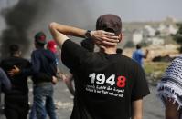 <p>A Palestinian protester wears a t-shirt with a political message during a protest in Ramallah, in the occupied West Bank, on May 15, 2018. (Photo: Abbas Momani/AFP/Getty Images) </p>