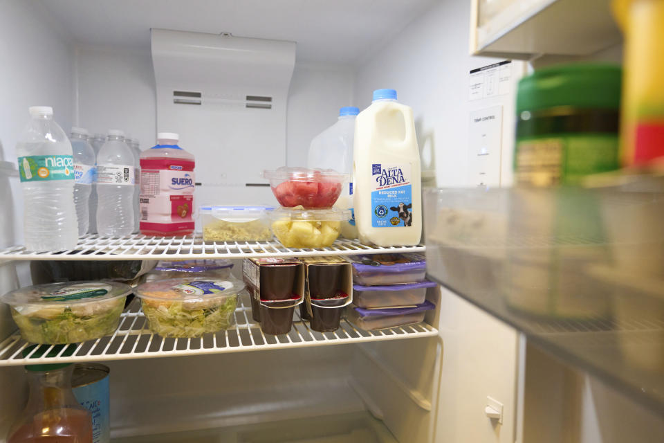 Jaqueline Benitez shows the inside of her refrigerator at her home in Bellflower, Calif., on Monday, Feb. 13, 2023. Benitez, 21, who works as a preschool teacher, depends on California's SNAP benefits to help pay for food, and starting in March she expects a significant cut, perhaps half, of the $250 in food benefits she has received since 2020. (AP Photo/Allison Dinner)