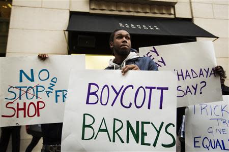 Demonstrators stand in front of a Barneys luxury department store of with signs decrying allegations that Barney's and Macy's stores have unfair security policies aimed at minorities in New York October 30, 2013. REUTERS/Lucas Jackson