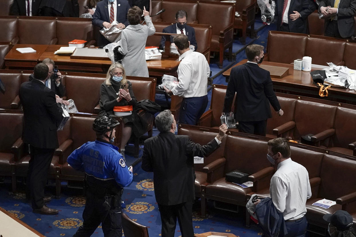 House of Representatives members leave the floor of the House chamber as protesters try to break into the chamber at the U.S. Capitol on Jan. 6, 2021, in Washington. (AP Photo/J. Scott Applewhite)