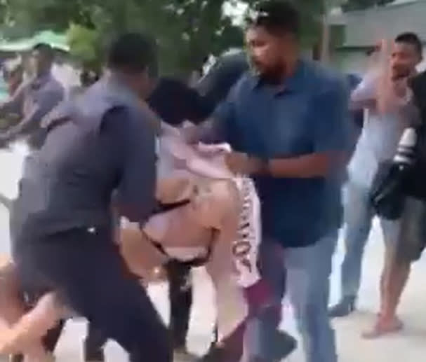 Picture six in a sequence of seven. Screengrab from video taken with permission from the Twitter feed of @MvCrisis which shows a tourist in a bikini being detained by at least three officers on the island of Maafushi, in the Kaafu atoll.