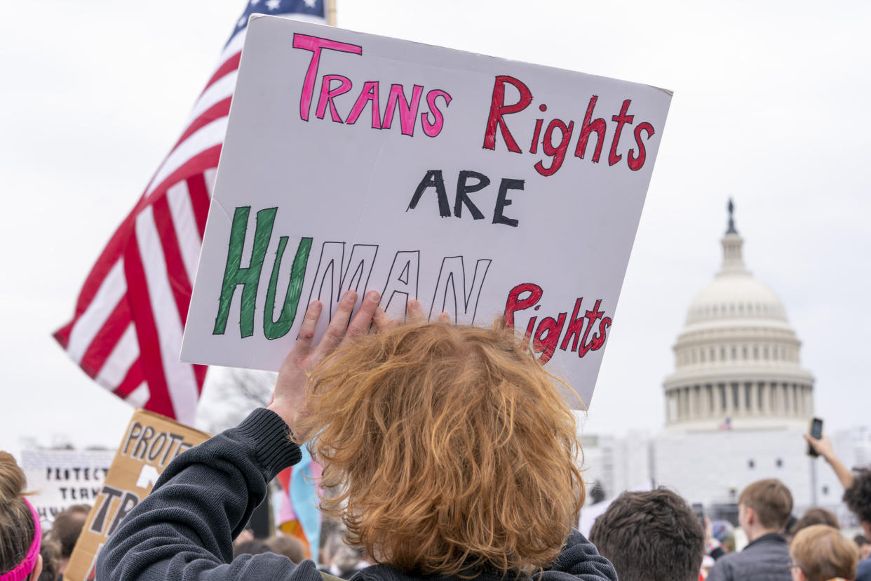 FILE - People attend a rally as part of a Transgender Day of Visibility, Friday, March 31, 2023, by the Capitol in Washington. Schools and colleges across the U.S. would be forbidden from enacting outright bans on transgender athletes under a proposal released Thursday, April 6, from the Biden administration, but teams could create some limits in certain cases, for example, to ensure fairness. (AP Photo/Jacquelyn Martin, File)