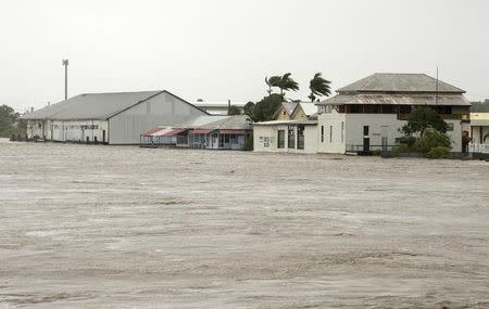 Buildings can be seen near the flooded Pioneer River after Cyclone Debbie hit the region in the northern Queensland town of Mackay in Australia, March 29, 2017. Picture taken March 29, 2017. AAP/Daryl Wright/via REUTERS