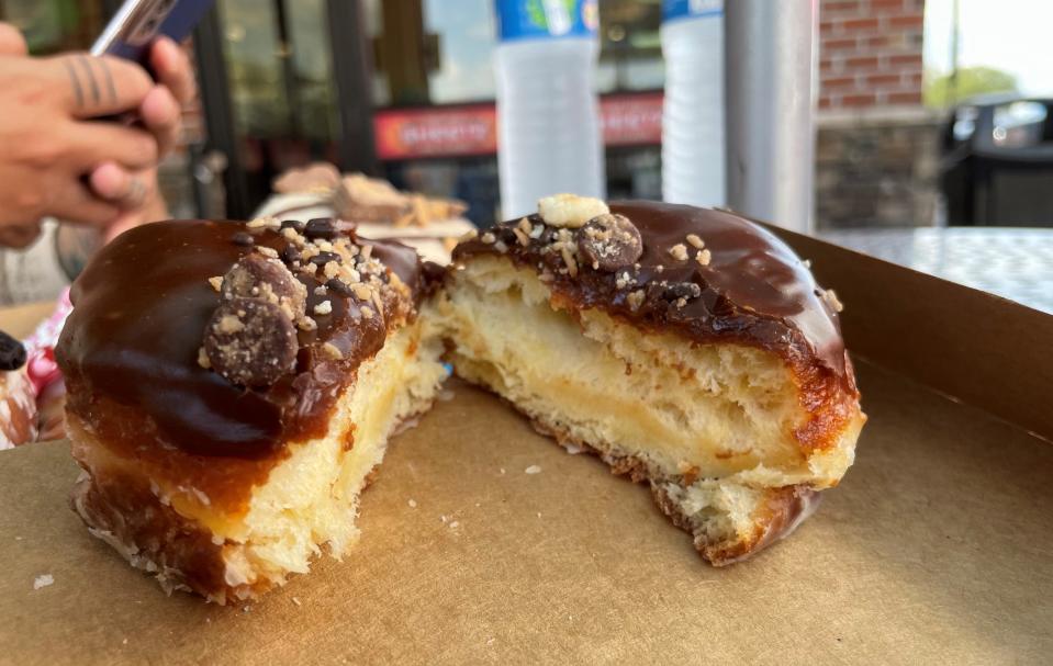 The coconut chocolate doughnut is topped with chocolate caramel icing, toasted coconut, chocolate and shortbread pieces.