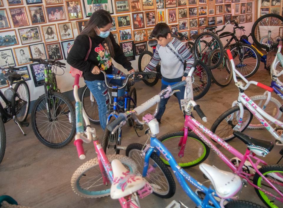 Eight-year-old Ricardo Beltran look at bicycles with his mother Liz Beltran at the 4th annual the Bikes For Kids event at Pete Paulsen's ranch in French Camp.