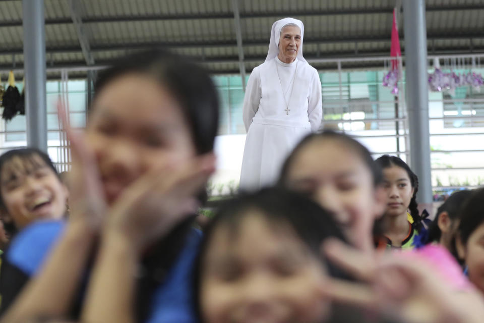 In this Aug. 27, 2019, photo, ST. Mary's School Vice Principal Sister Ana Rosa Sivori, rear, watches students play during a lunch break at the girls' school in Udon Thani, about 570 kilometers (355 miles) northeast of Bangkok, Thailand. Sister Ana Rosa Sivori, originally from Buenos Aires in Argentina, shares a great-grandfather with Jorge Mario Bergoglio, who, six years ago, became Pope Francis. So, she and the pontiff are second cousins. (AP Photo/Sakchai Lalit)