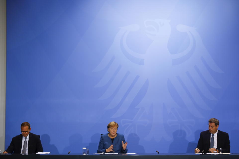German Chancellor Angela Merkel (CDU), Bavarian Prime Minister Markus Soeder (CSU), right, and Berlin's Mayor Michael Mueller (SPD) hold a press conference at the Chancellery in Berlin, Wednesday, Oct. 28, 2020. Merkel is pressing for a partial lockdown as the number of newly recorded infections in the country hit another record high Wednesday. (Fabrizio Bensch/pool photo via AP)