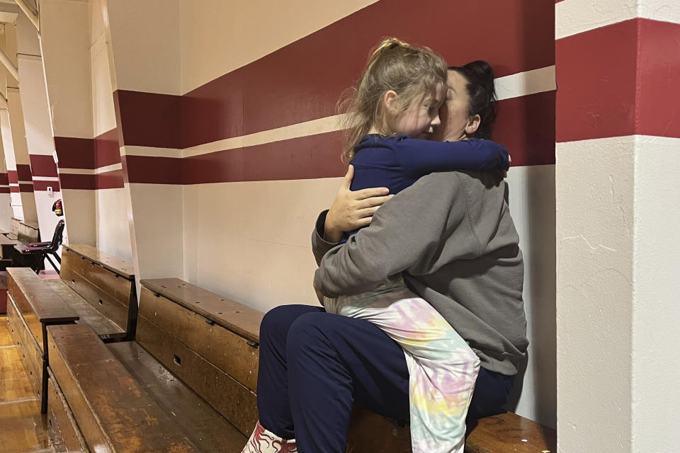 Angela Stires is embraced by her daughter, Tuesday, Nov. 21, 2023, at the community center, which opened for people displaced by the landslide in Wrangell, Alaska. Stires lives about a mile farther down the highway from the slide zone and evacuated after the slide cut access to homes in the area. (Mark C. Robinson/Wrangell Sentinel via AP)