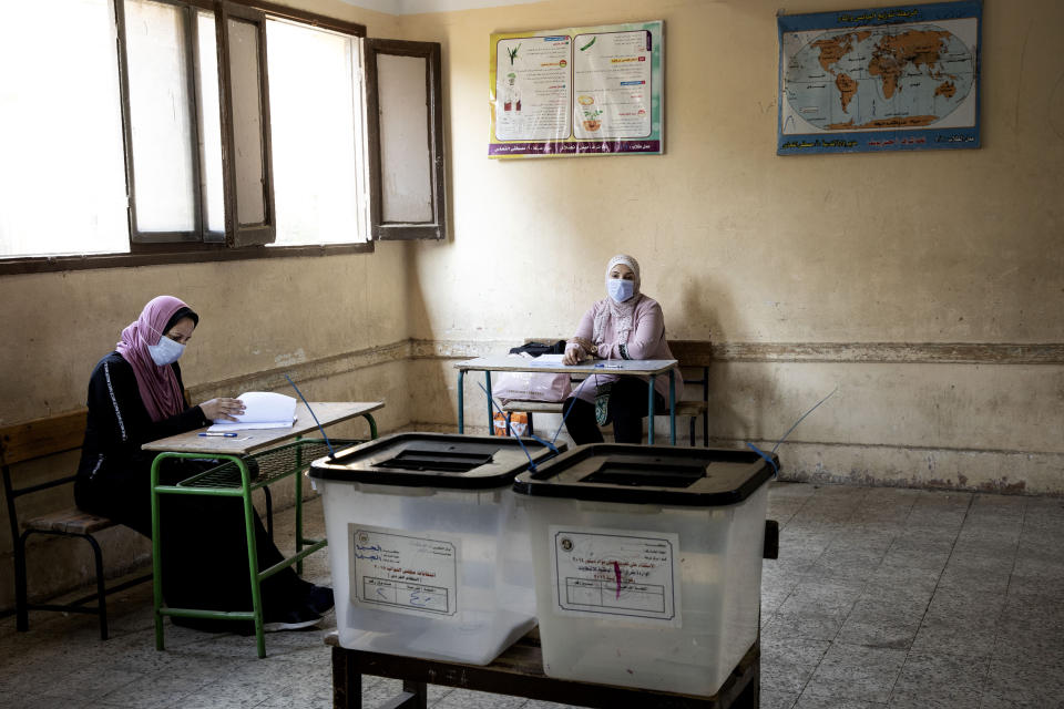 Election officials wait for people to vote on the first day of the Senate elections inside a polling station in Cairo, Egypt, Tuesday, Aug. 11, 2020. Egyptians started voting on Tuesday for the Senate, the upper chamber of parliament that was revived as part of constitutional amendments approved in a referendum last year — an election that comes as the country faces an uptick in daily numbers of new coronavirus cases. (AP Photo/Nariman El-Mofty)