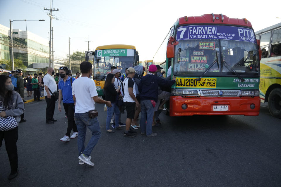 Commuters rush to ride a bus during a transport strike in Quezon city, Philippines on Monday, March 6, 2023. Philippine transport groups launched a nationwide strike Monday to protest a government program drivers fear would phase out traditional jeepneys, which have become a cultural icon, and other aging public transport vehicles. (AP Photo/Aaron Favila)