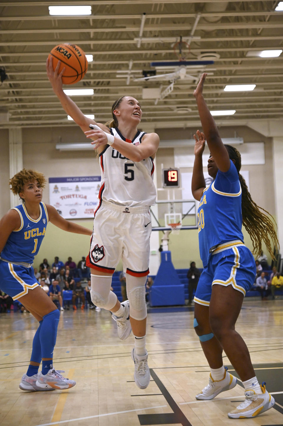 UConn's Paige Bueckers shoots as UCLA's Charisma Osbourne, right, defends during the first half of an NCAA college basketball game at the Cayman Islands Classic in George Town, Cayman Islands, Friday, Nov. 24, 2023. (AP Photo/Kevin Morales)