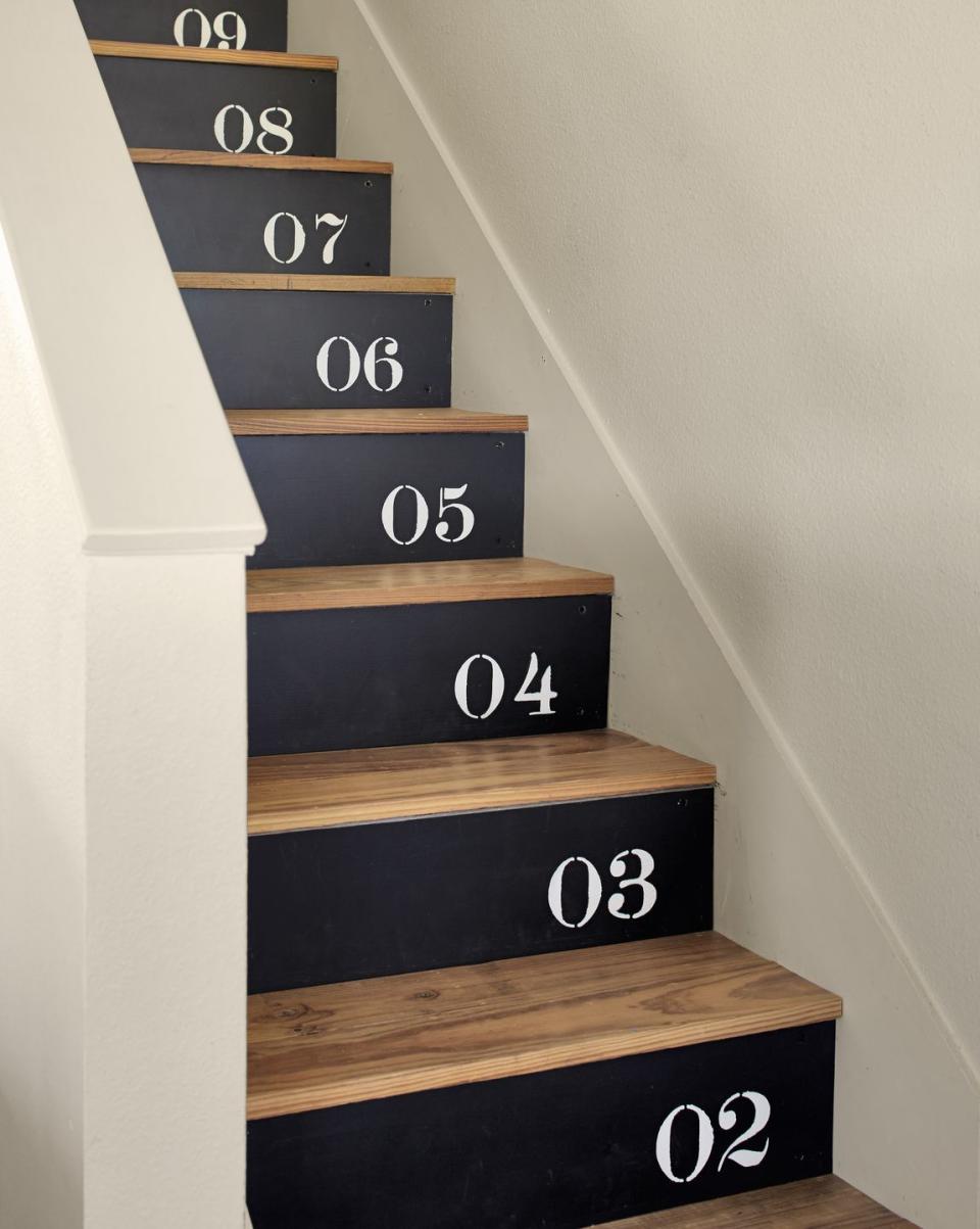 <p>Try a fun stenciled pattern on stair risers. Here, the family applied bright white numbers in ascending order on matte black painted plywood, which they then nailed to the stair risers. Other ideas for stair risers include painting each a different color (think rainbow, ombre, or alternating hues) or applying a more decorative stencil to mimc the look of tile.</p>