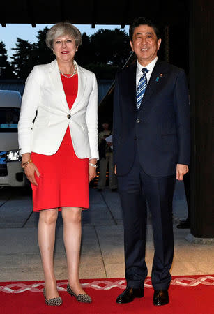 British Prime Minister Theresa May poses with Japanese Prime Minister Shinzo Abe upon her arrival for a Japan-UK dinner at the Kyoto State Guest House in Kyoto, Japan 30 August, 2017. REUTERS/Franck Robichon/Pool