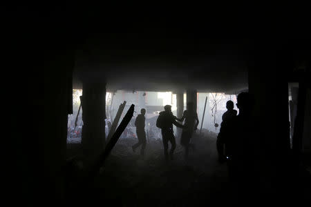Palestinians run inside a building that was hit by an Israeli air strike, in the southern Gaza Strip May 5, 2019. REUTERS/Ibraheem Abu Mustafa