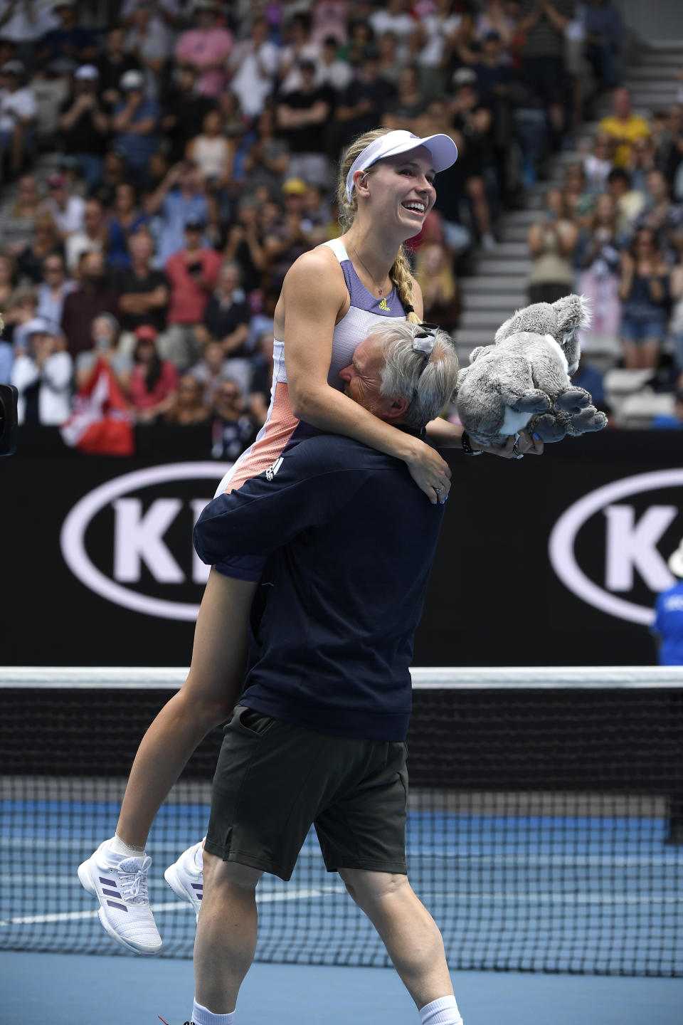 Denmark's Caroline Wozniacki is lifted by her coach and father Piotr after her third round loss to Tunisia's Ons Jabeur at the Australian Open tennis championship in Melbourne, Australia, Friday, Jan. 24, 2020. (AP Photo/Andy Brownbill)