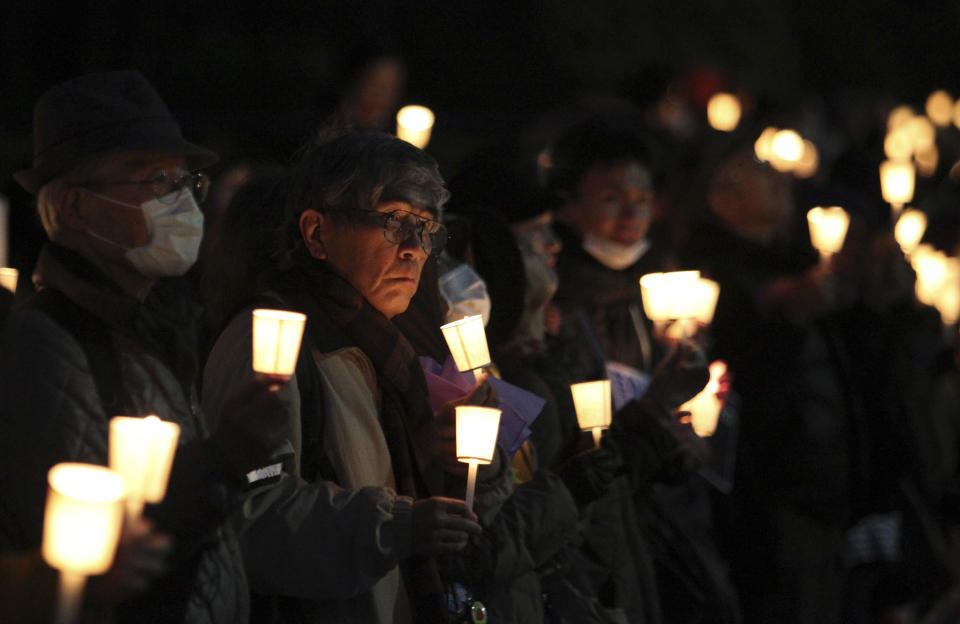 Participants hold candles while forming a "human chain" around Japan's parliament building during a candle light vigil against nuclear power plants in Tokyo, Sunday, March 11, 2012. Japan marked the first anniversary of the March 11 earthquake and tsunami which devastated Japan's northeast and triggered a massive nuclear power plant accident in Fukushima. (AP Photo/Junji Kurokawa)
