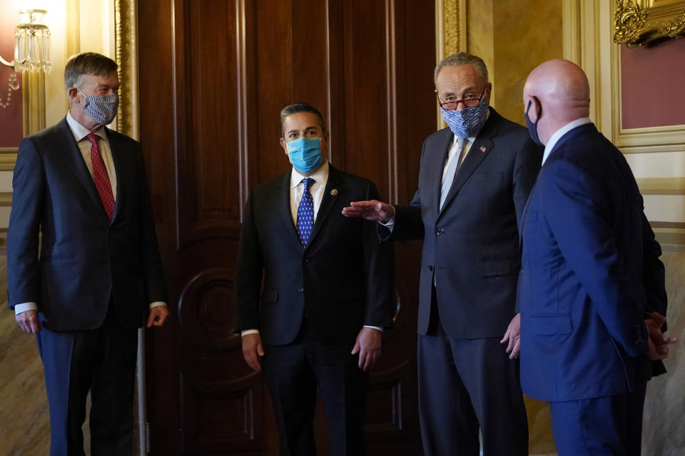 Senate Minority Leader Sen. Chuck Schumer of N.Y., second from right, talks with the newly elected senators, from left, Sen.-elect John Hickenlooper, D-Colo., Sen.-elect Ben Ray Lujan, D-N.M., and Sen.-elect Mark Kelly, D-Ariz., before a meeting on Capitol Hill in Washington, Monday, Nov. 9, 2020. (AP Photo/Susan Walsh)