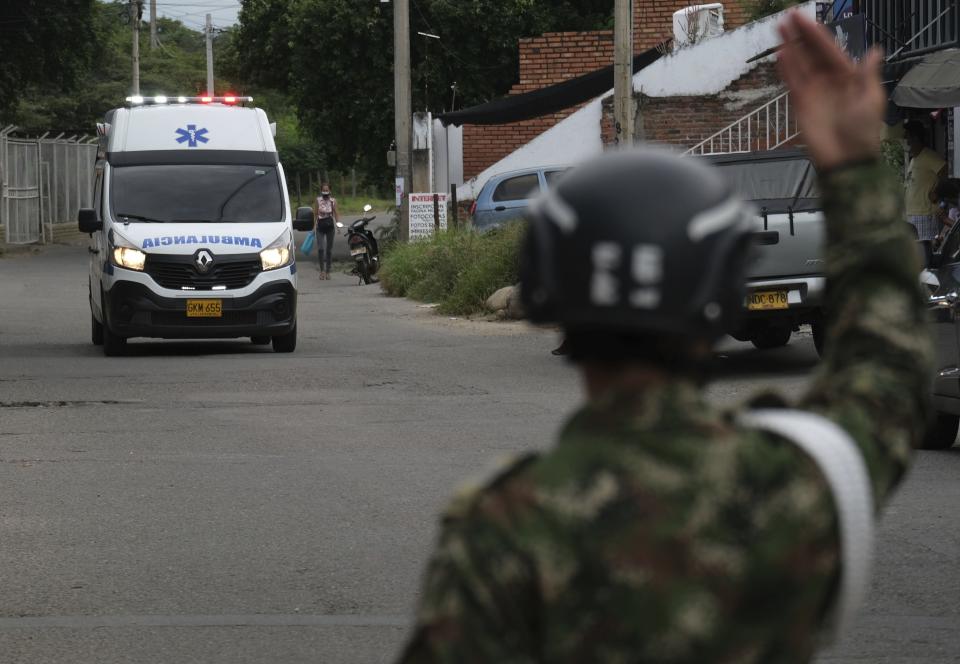 A soldier signals an ambulance as it drives towards the military base where a car bomb exploded in Cucuta, Colombia, Tuesday, June 15, 2021. Colombian authorities still have not confirmed how many were injured in the explosion. (AP Photo/Ferley Ospina)