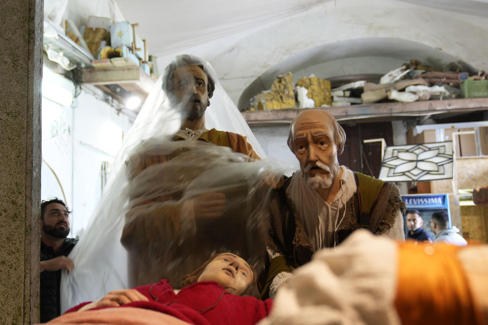 An artisan gives the last touch to a "Mistero" a float depicting a biblical scene in a workshop set n the former prison of Procida Island, Italy, Thursday, March 28, 2024. Italy is known for the religious processions that take over towns big and small when Catholic feast days are celebrated throughout the year. But even in a country where public displays of popular piety are a centuries-old tradition, Procida's Holy Week commemorations stand out. (AP Photo/Alessandra Tarantino)